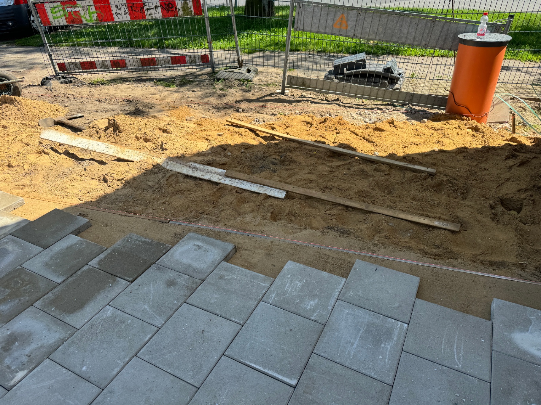 Pflasterarbeiten mit Betonplatten auf Sandbett im Außenbereich
